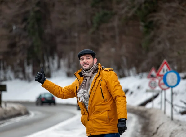 Mid Adult Man Hitchhiking Snow Mountains Road — стоковое фото