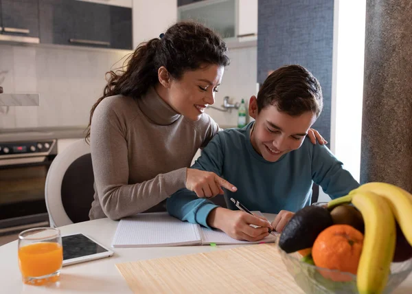 Mother Sitting Son While Doing Homework Table Kitchen Smiling Happy — Stockfoto