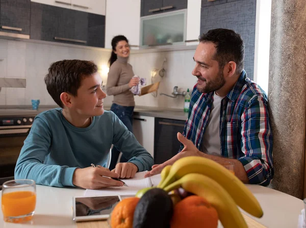 Father Son Sitting Dining Table Doing Homework Talking Smiling While — Photo