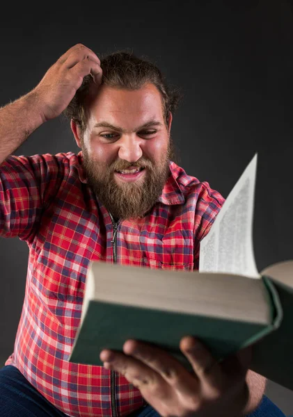 Young Man Feeling Uncertain While Reading Book — Stock Photo, Image