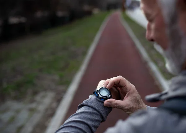 Vue Arrière Homme Âgé Regardant Smartwatch Avant Courir Sur Piste — Photo
