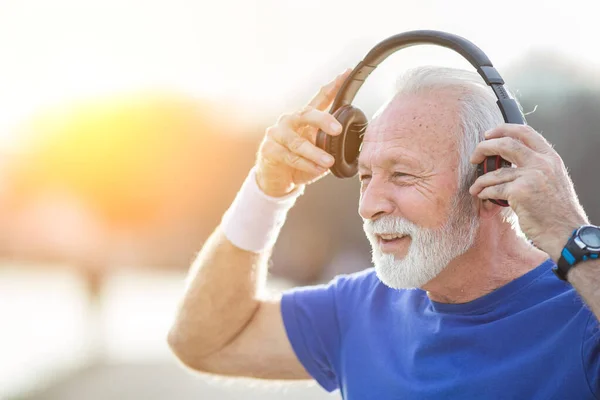 Starszy Uśmiechnięty Mężczyzna Brodą Odzieży Sportowej Zakłada Słuchawki Przygotowuje Się — Zdjęcie stockowe
