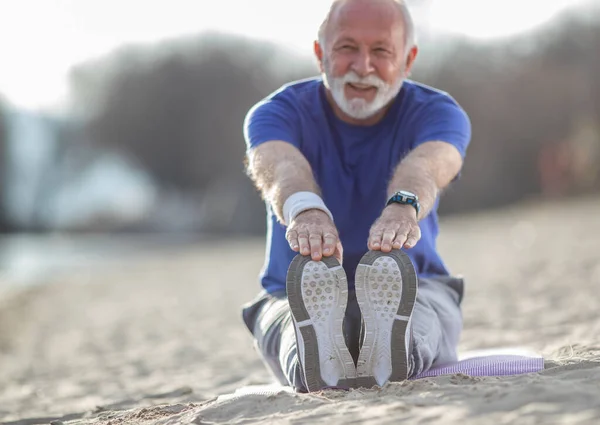 Senior Man Beard Sportswear Stretching Beach While Sitting Sand Wearing — Stock Photo, Image