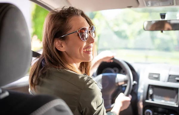 Bonita Jovem Sorridente Motorista Mulher Dirigindo Carro Usando Óculos Sol — Fotografia de Stock