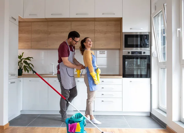 Couple Cleaning Equipment Prepares Clean Apartment Together While Man Ties — Fotografia de Stock