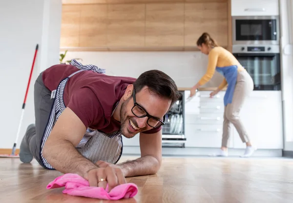 Sorrindo Homem Joelhos Polir Chão Com Pano Enquanto Mulher Fundo — Fotografia de Stock