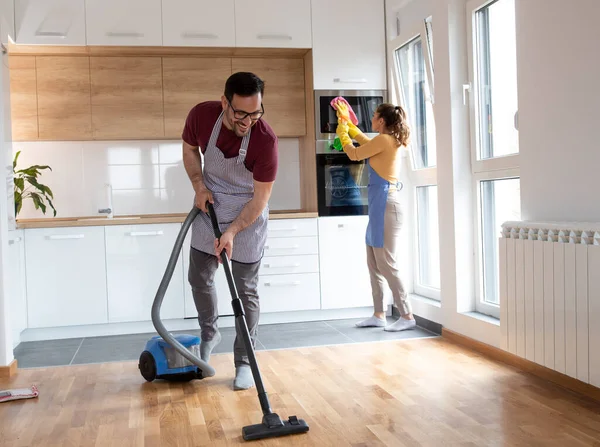 Couple Doing Chores Together While Woman Wipes Dust Man Vacuuming — Fotografia de Stock