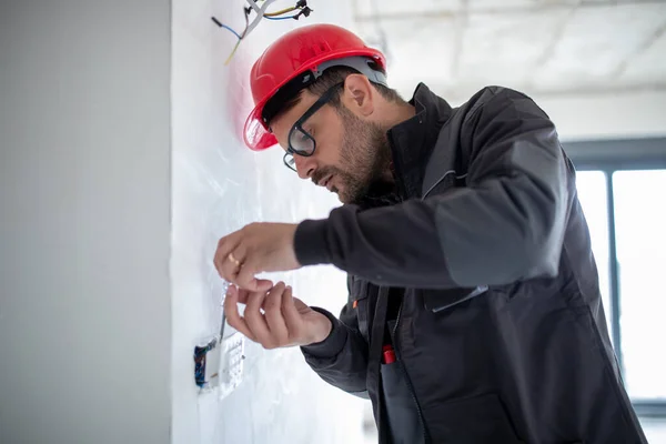 Serious Male Electrician Helmet Installing Power Socket Apartment Using Screwdriver —  Fotos de Stock