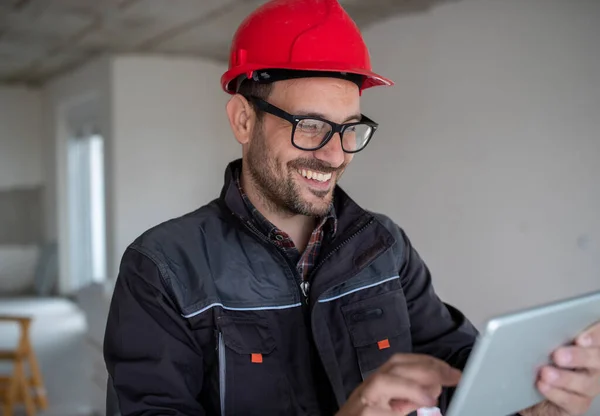 Jovem Sorridente Engenheiro Masculino Uniforme Protetor Com Capacete Usando Tablet — Fotografia de Stock