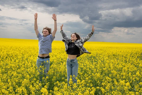 Pareja Joven Saltando Campo Semillas Oleaginosas Amarillas Maduras Primavera Concepto —  Fotos de Stock