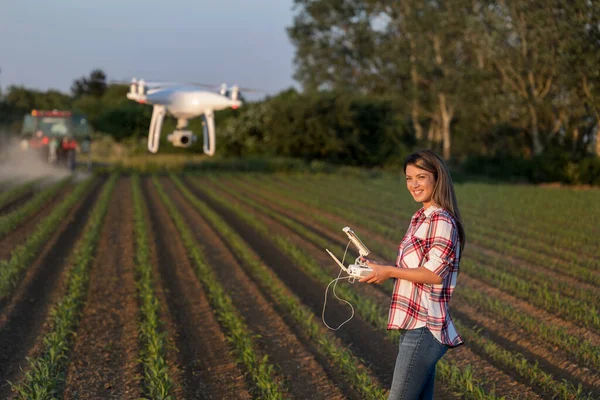 Ładny Młody Rolnik Kobieta Jazdy Drone Pilotem Przed Ciągnikiem Polu — Zdjęcie stockowe