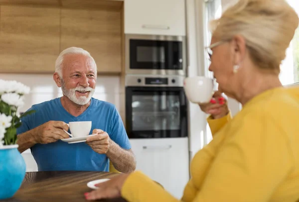 Senior Couple Sitting Dining Table Kitchen Drinking Coffee Talking — Stockfoto