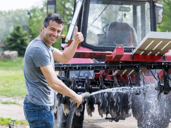 Handsome Satisfied Man Cleaning Tractor Equipment Water Stream Hose Showing — Foto de Stock