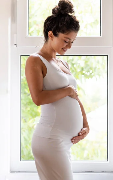 Vacker Gravid Kvinna Vitt Håller Händerna Magen Framför Fönstret Moderskapsperiod — Stockfoto