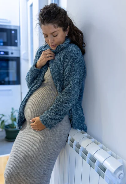 Gravid Kvinna Fryser Och Försöker Värma Sig Med Tröja Kylarvärmaren — Stockfoto