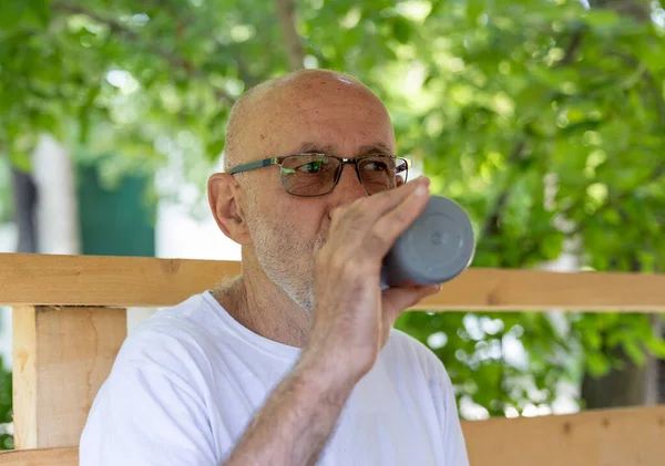 快乐的老年人在户外活动后从瓶子里喝水 — 图库照片