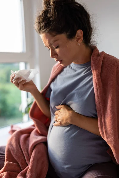 妊娠中の女性は毛布でベッドに座って組織にくしゃみをした 産前期間における風邪やウイルスの概念 — ストック写真