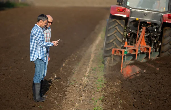 Zwei Gestandene Bauern Schauen Auf Tablet Neben Traktor Der Feld — Stockfoto