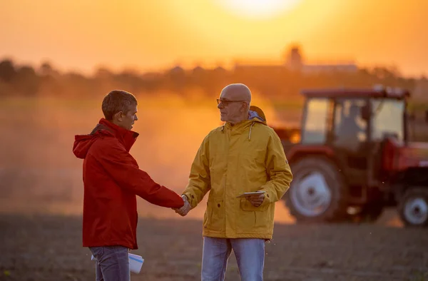 Dos Granjeros Mayores Estrechando Mano Campo Atardecer Otoño Mientras Tractor — Foto de Stock