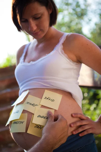 Pregnant woman with stick notes on her belly — Stock Photo, Image