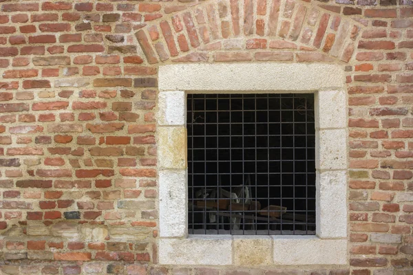 Old red brick wall with bars window — Stock Photo, Image