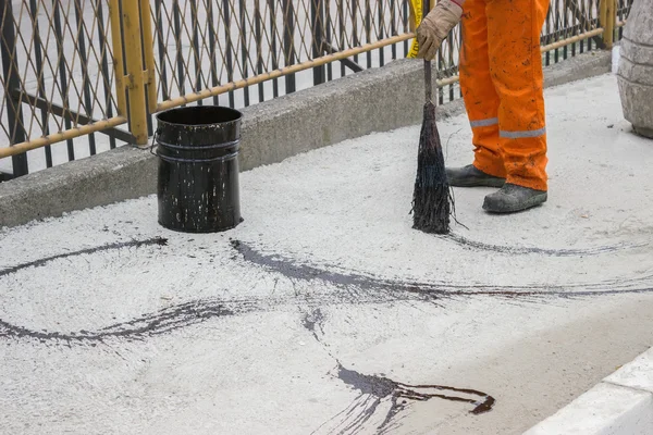 Asphalt pekerja menerapkan mantel paku (Bitumen Emulsion) dengan sapu 2 — Stok Foto