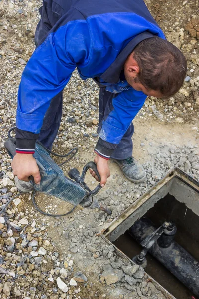 Een werknemer met behulp van perforator te breken conctrete — Stockfoto