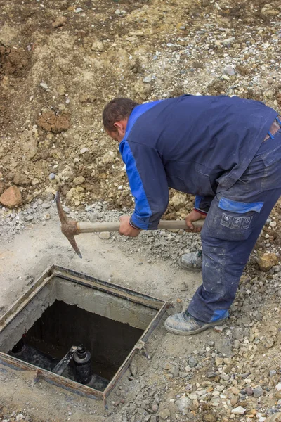 Un trabajador usando hacha de pico para romper conctreta — Foto de Stock