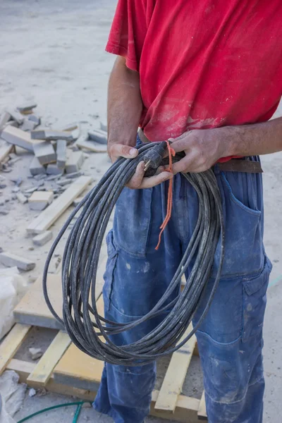 Trabalhador da construção civil com cabo elétrico — Fotografia de Stock