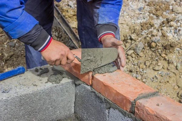 Homem que coloca bloco de concreto e tijolos parede 2 — Fotografia de Stock