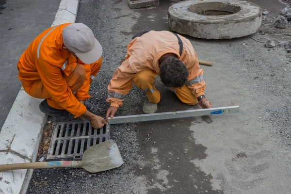 Les ouvriers sur la construction de la route fixaient les lignes de corde et levaient — Photo