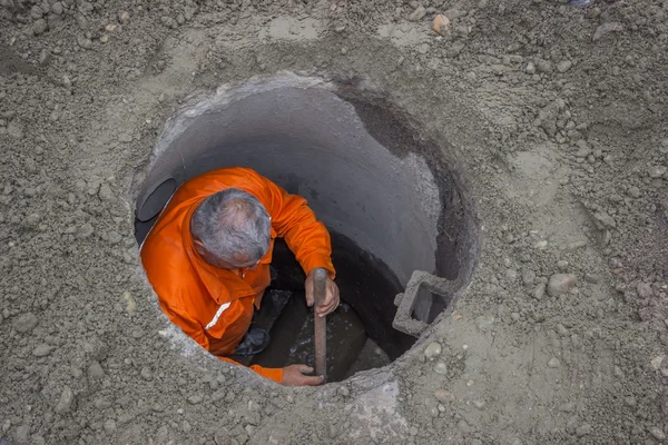 Lavorare in un tombino, lavoratore all'interno di un tombino 4 — Foto Stock