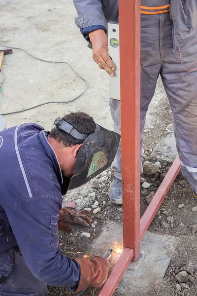 Los trabajadores trabajan con un nivel y soldadura —  Fotos de Stock