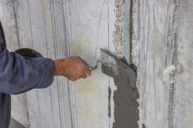Trowel spreading mortar on concrete wall 2 clipart