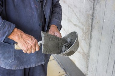 Trowel spreading mortar on concrete wall clipart