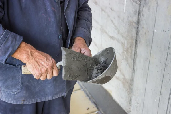 Espátula espalhando argamassa na parede de concreto — Fotografia de Stock