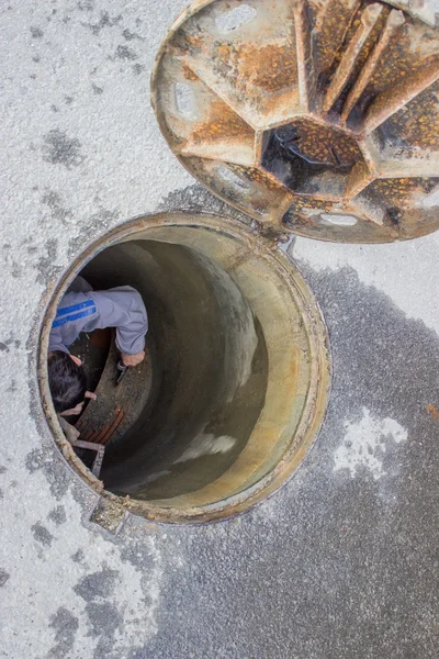 Человек чистит засоренные стоки 2 — стоковое фото