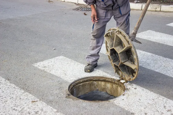 Utilities worker moves the manhole cover 2 — Stock Photo, Image