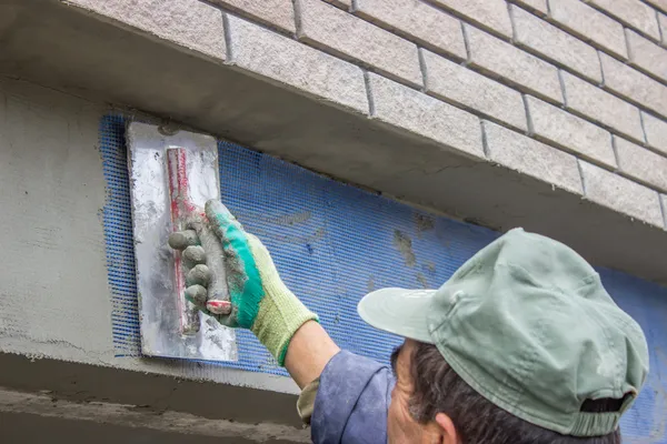 Trabajador de la construcción establece rejilla de plástico — Foto de Stock