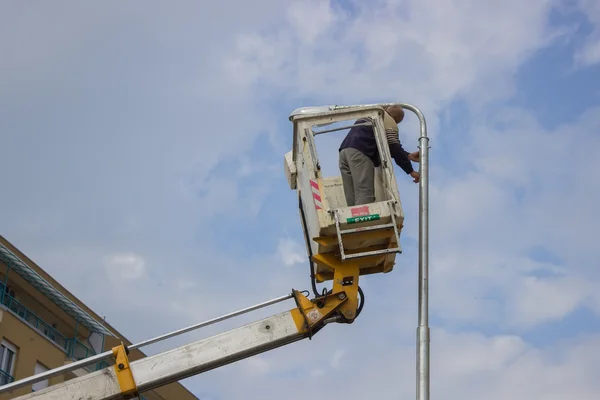 Pracovník na vrcholu sloupu, stanovení dodávek — Stock fotografie
