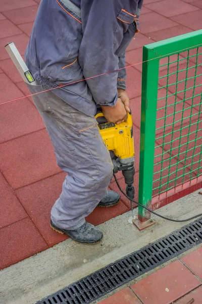 Construction worker uses a drill to make holes in a concrete 2 — Stock Photo, Image
