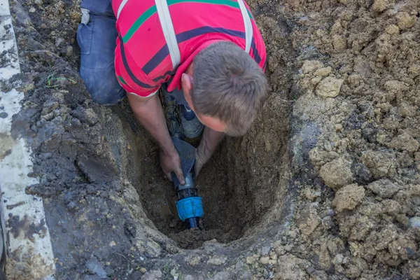 Verktyget arbetare i diket reparera trasiga röret 2 — Stockfoto