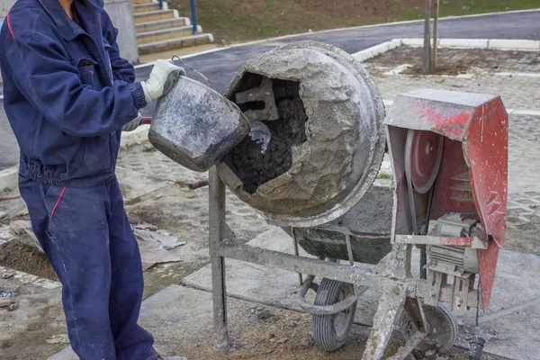 Trabalhador do construtor colocando água em um misturador de cimento 2 — Fotografia de Stock