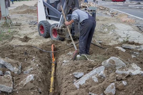 Mini excavator digging up a electrical cables from trench 3 — Stock Image Mini excavator digging up a electrical cables from trench 3 Royalty Free Stock Photos