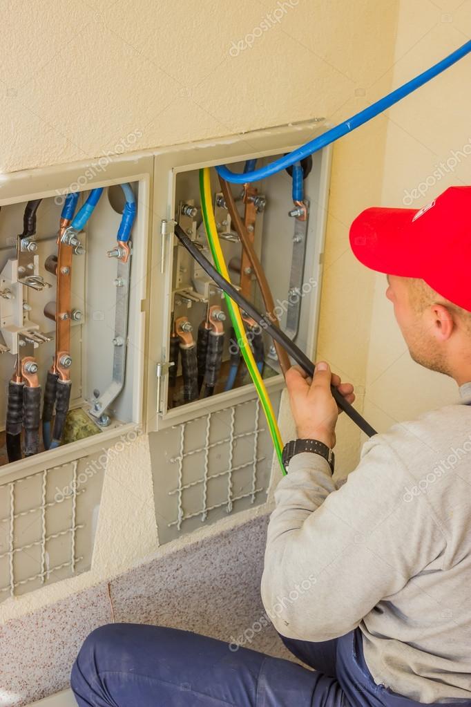Electrician connecting copper power cables with connectors 2 Stock