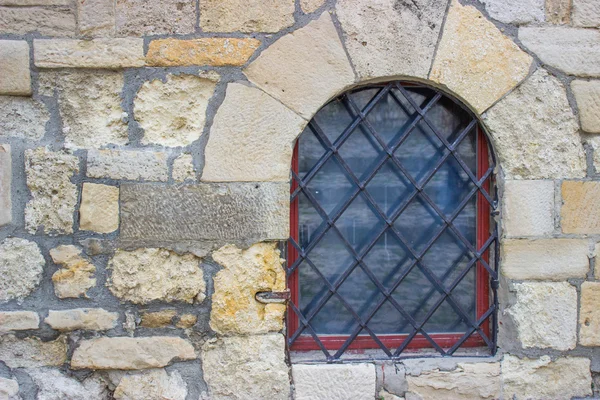 Window with bars in the stone wall — Stock Photo, Image