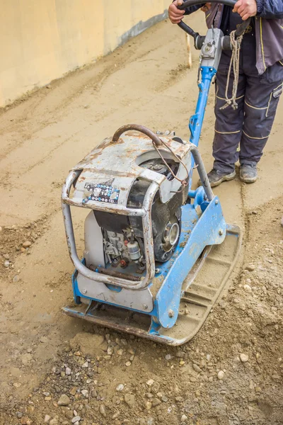 Trabalhador com máquina de compactador de placa vibratória — Fotografia de Stock