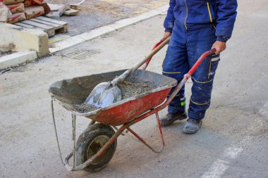 builder worker pushing gravel wheelbarrow clipart
