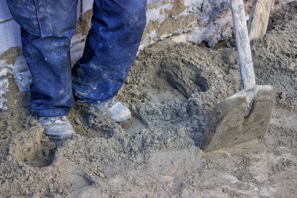 Tukang bangunan mengotori pasir dengan 2 kaki. — Stok Foto