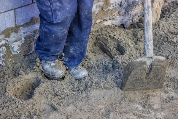 Trabalhador construtor que domina cama de areia com um pé — Fotografia de Stock